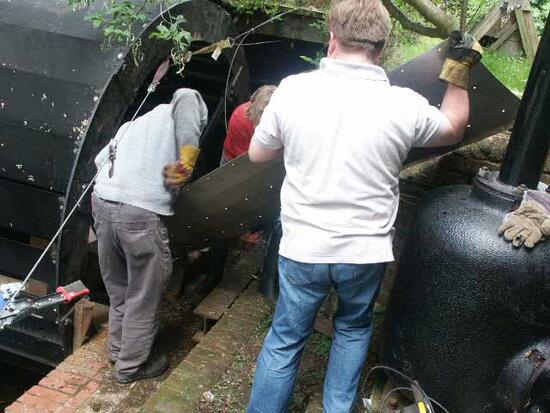 Fitting a new stainless steel lining plate to the inside of the waterwheel